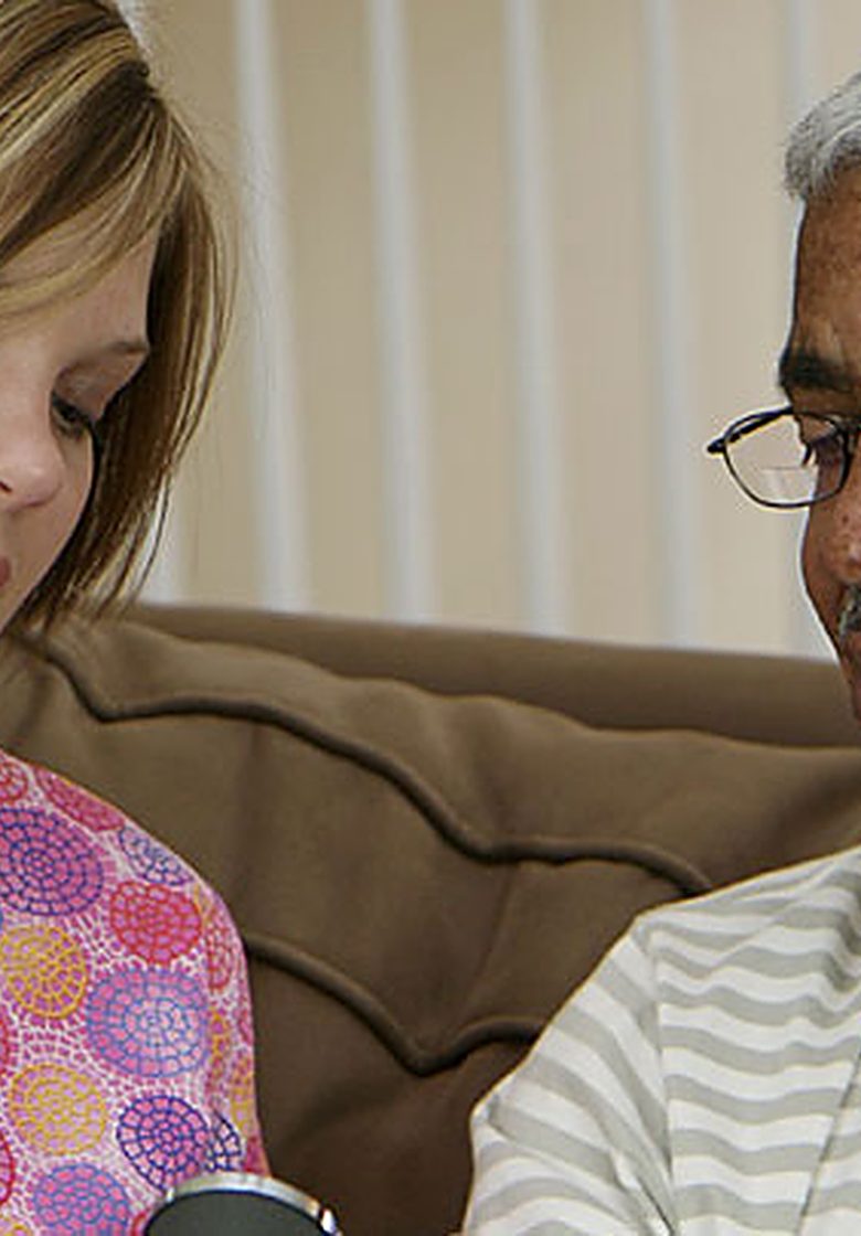 A nurse listening to an older patient's heart during a home visit